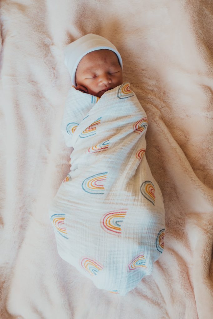 newborn photoshoot with baby wrapped in a swaddle blanket