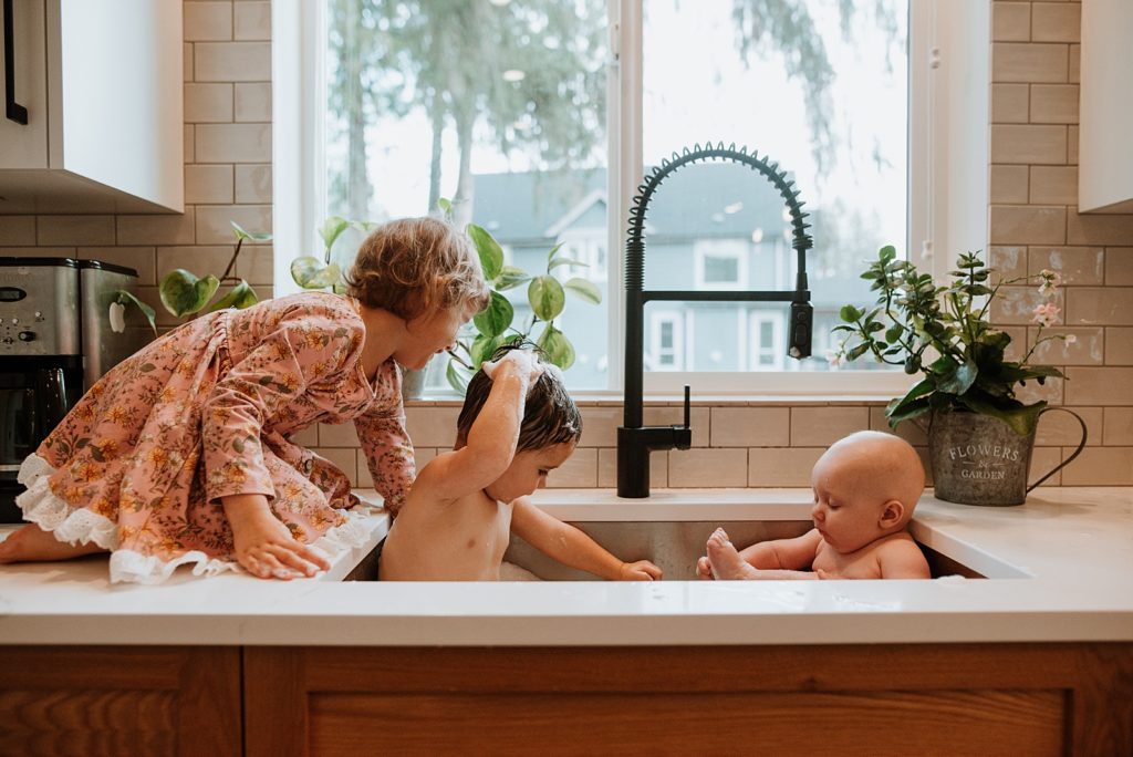 Kids in a sink bath at an in-home family photography session