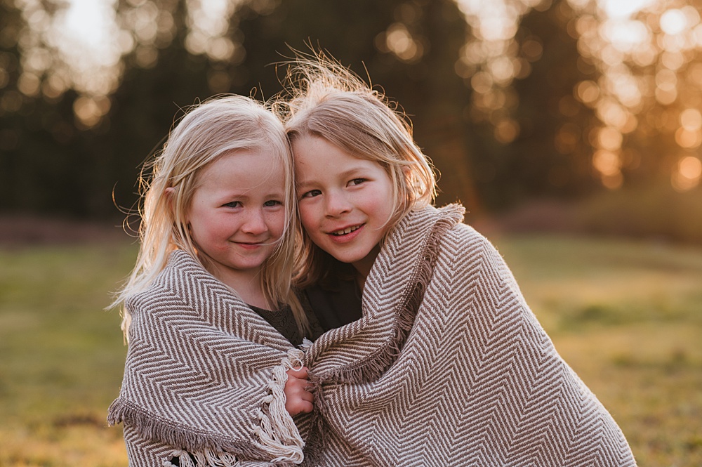 Sister and brother wrapped in blanket. Find spring camps for kids in Vancouver.