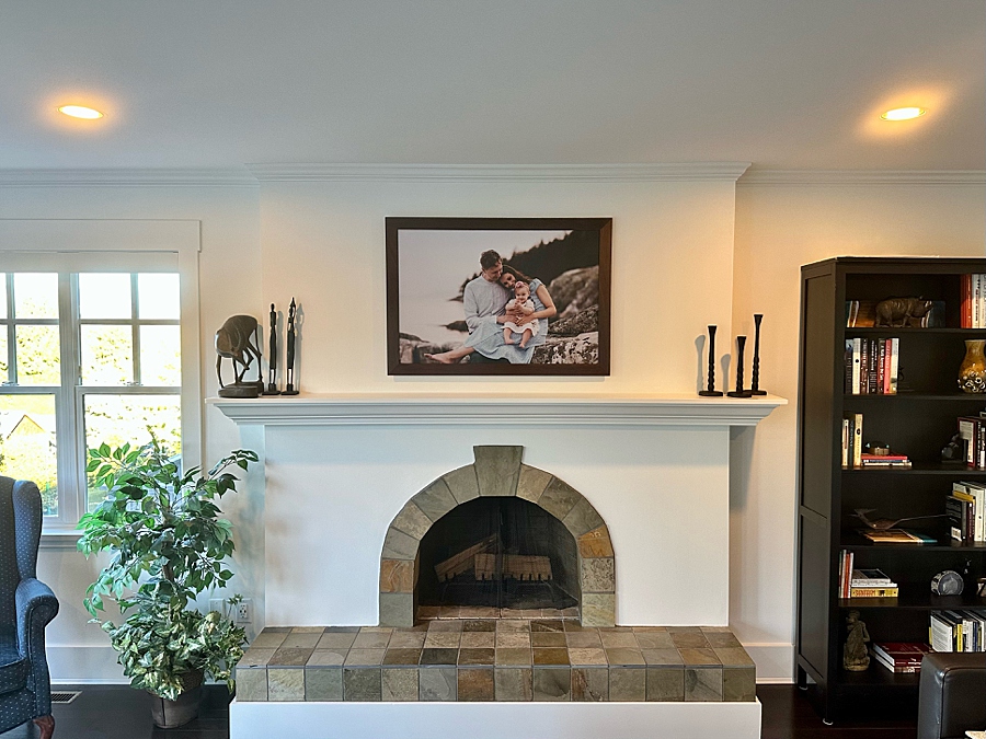 Family of three in frame above a fireplace.Why having your family photos on your walls is so important