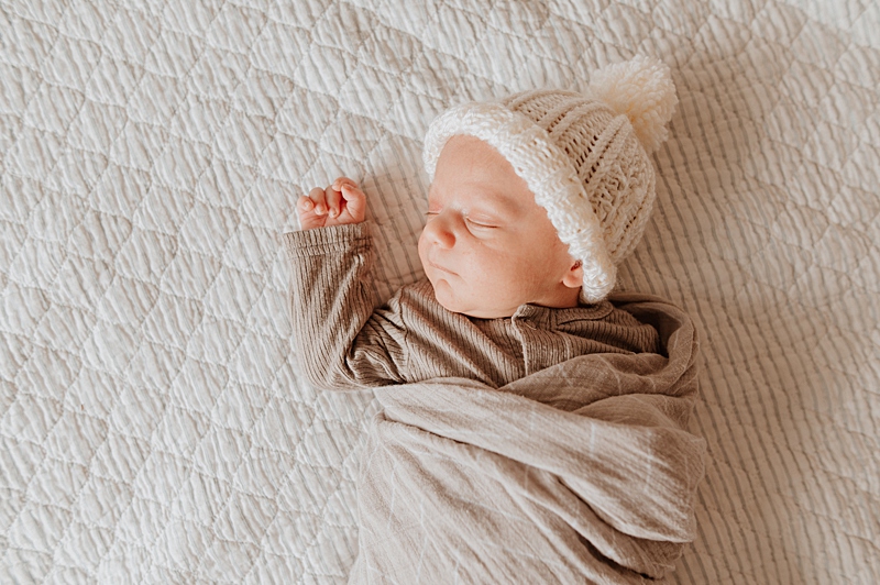newborn baby sleeping wearing a hat for a newborn photoshoot in Vancouver BC