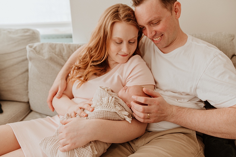 parents holding a newborn baby at home