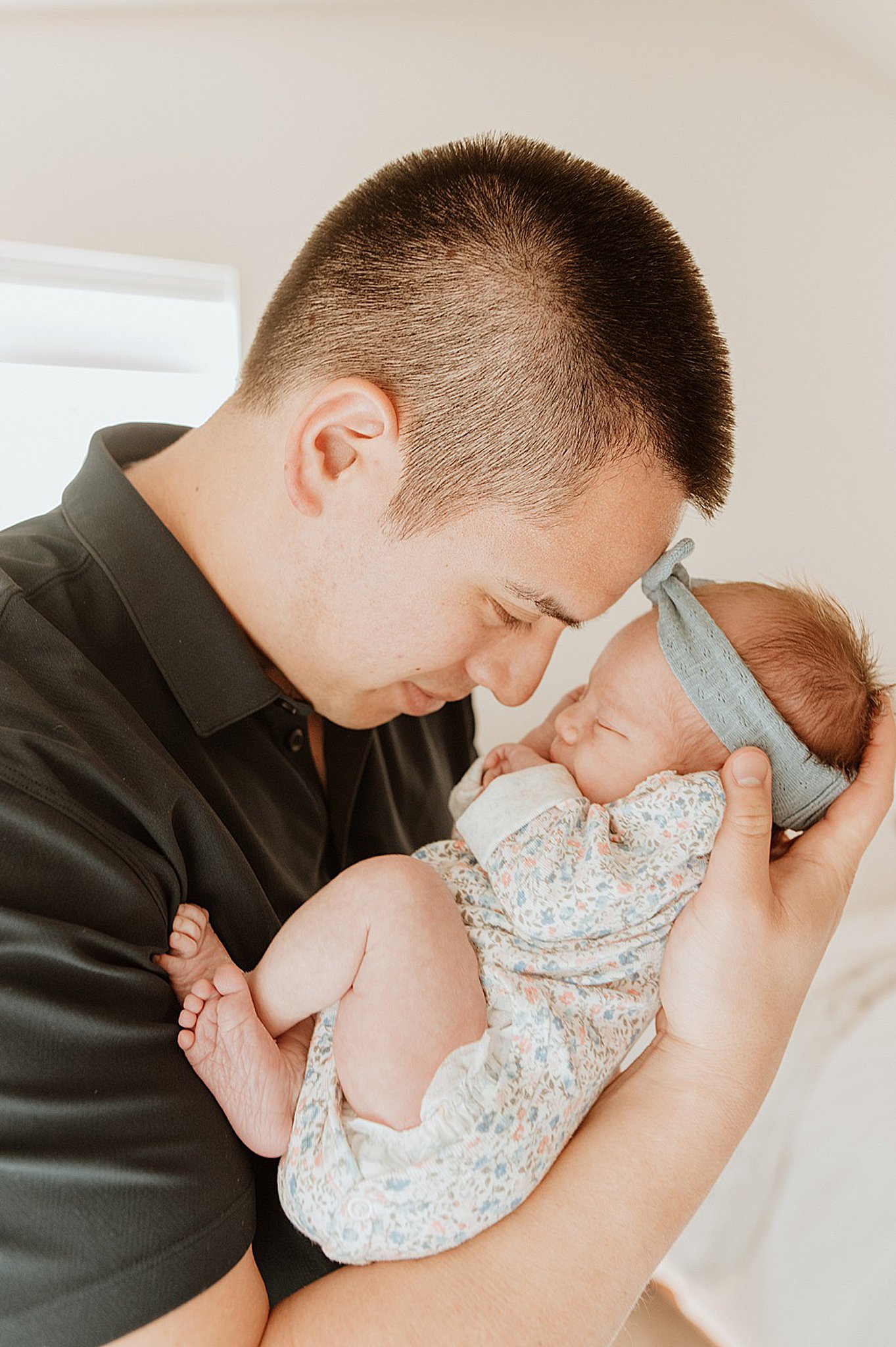 A happy new father snuggles his sleeping newborn baby in his hand after meeting nannies on call vancouver