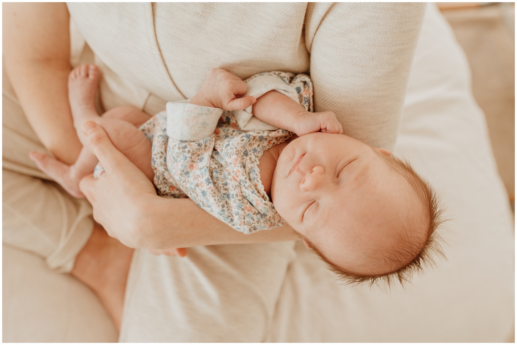 A newborn baby sleeps in mom's arms on a bed thanks to sleep training vancouver