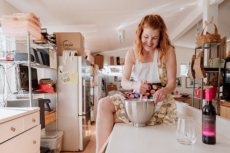 Woman smiling while arranging macarons in her bakery – Vancouver small business brand photography