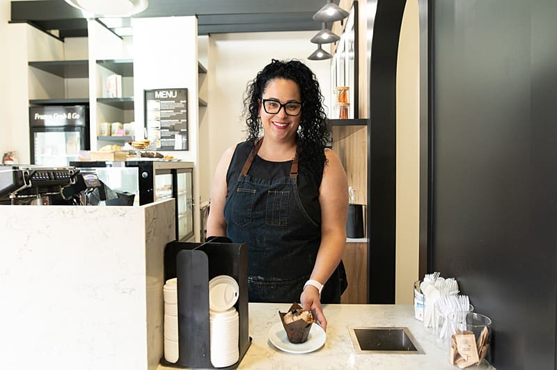 Environmental portrait of Jenna from Caffe Delish making and serving coffee during our branding photography session