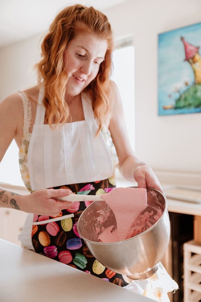 Entrepreneur laughing while working in a bright creative space — personal branding portrait showing authenticity and warmth.