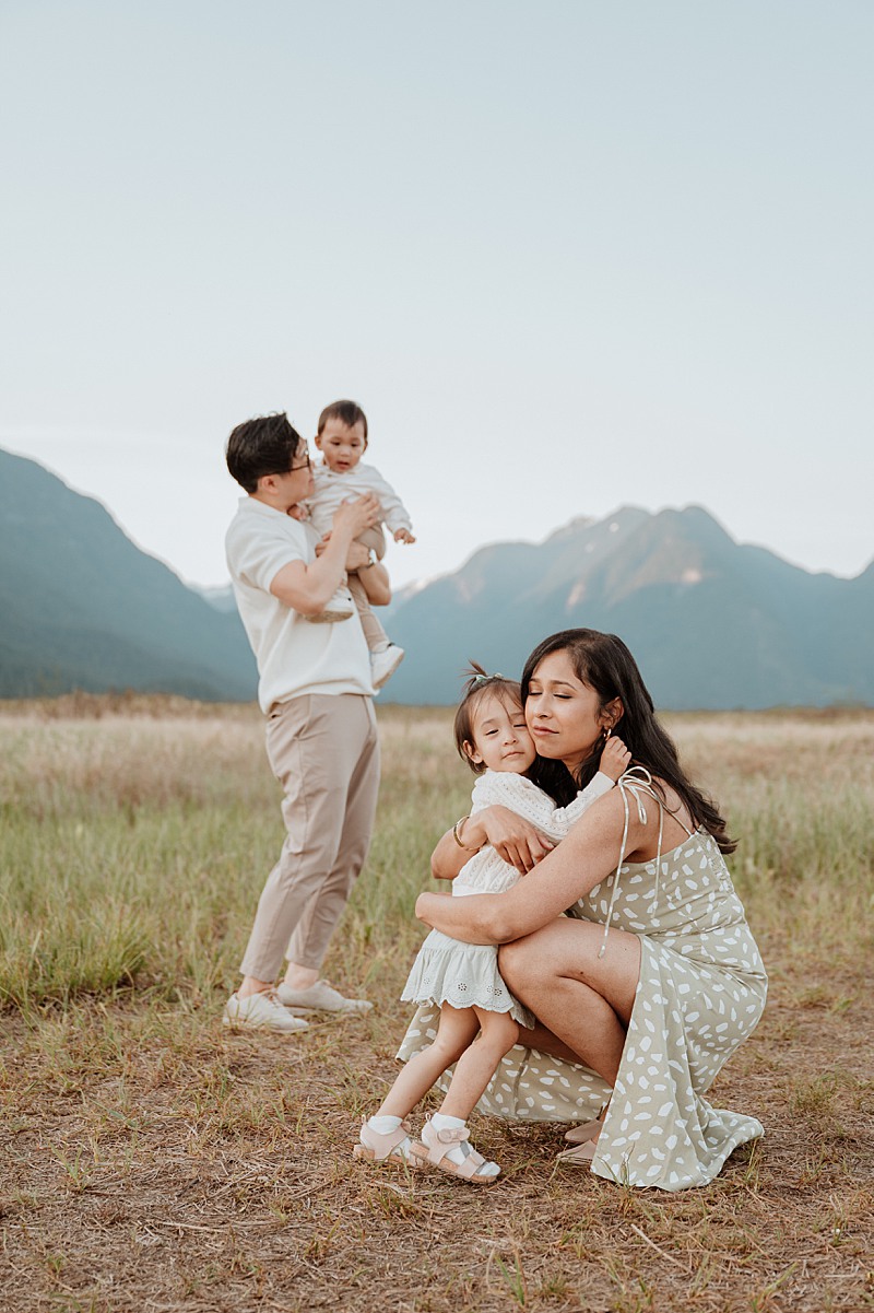 Mom hugging daughter and dad plying with son during Vancouver luxury photo session