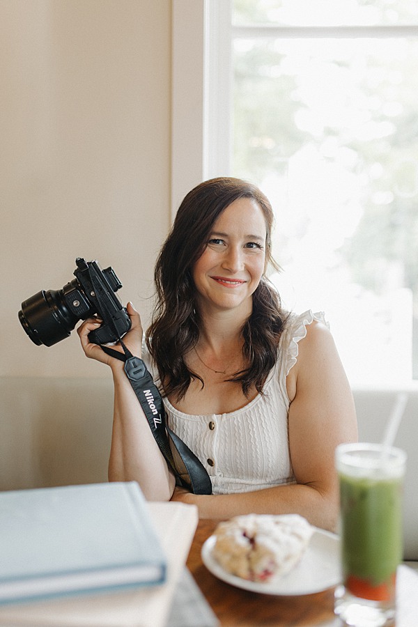 Vancouver portrait photographer holding her camera and smiling at the camera