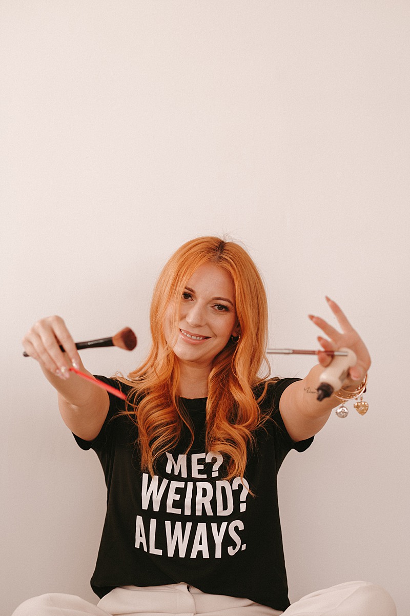 Makeup artist holding out makeup brushes and smiling at her vancouver marketing photography session