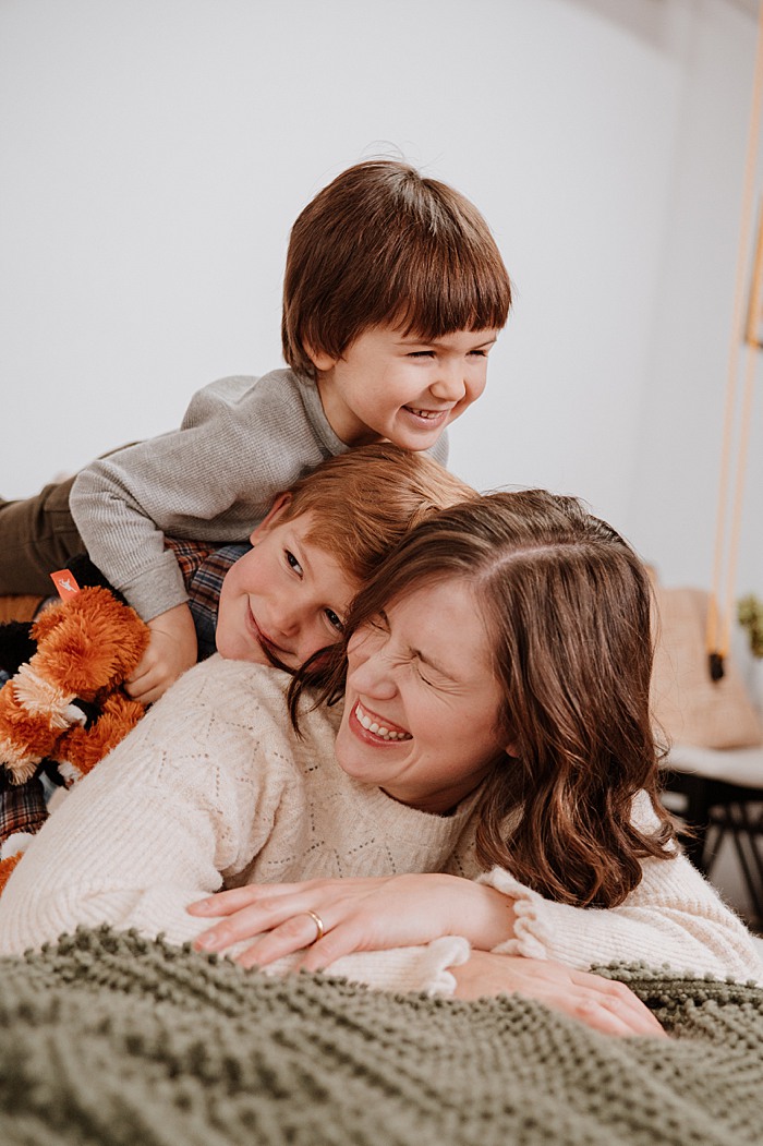 Mom with two boys climbing on her