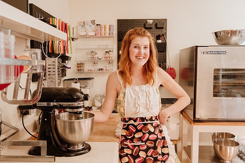 baker stands next to her stand mixer during brand photography session